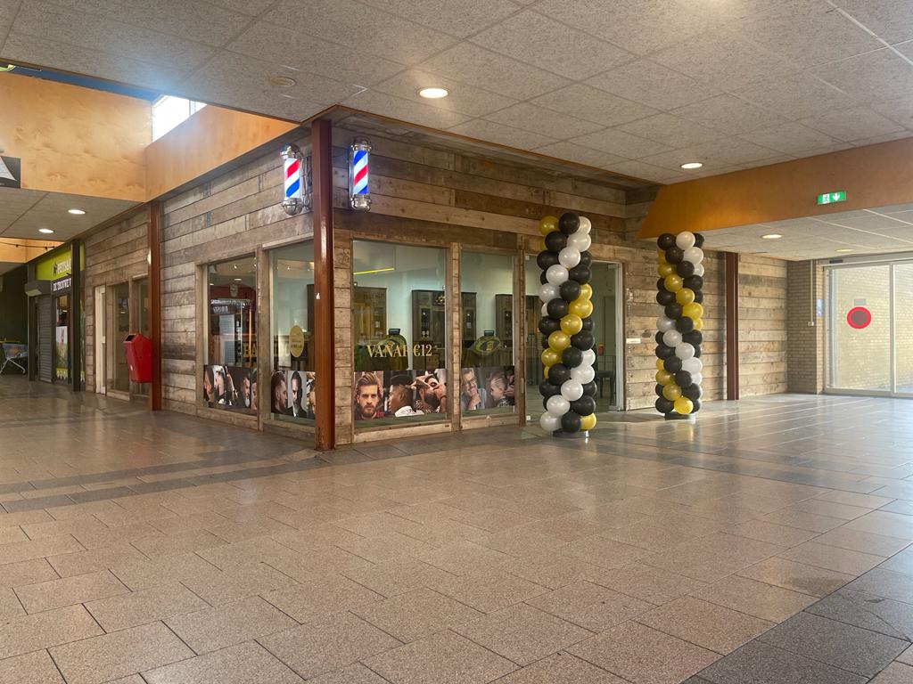 De winkel in Winkelcentrum Dauwendaele bij de opening, met zwart-gele ballonnen bij de ingang