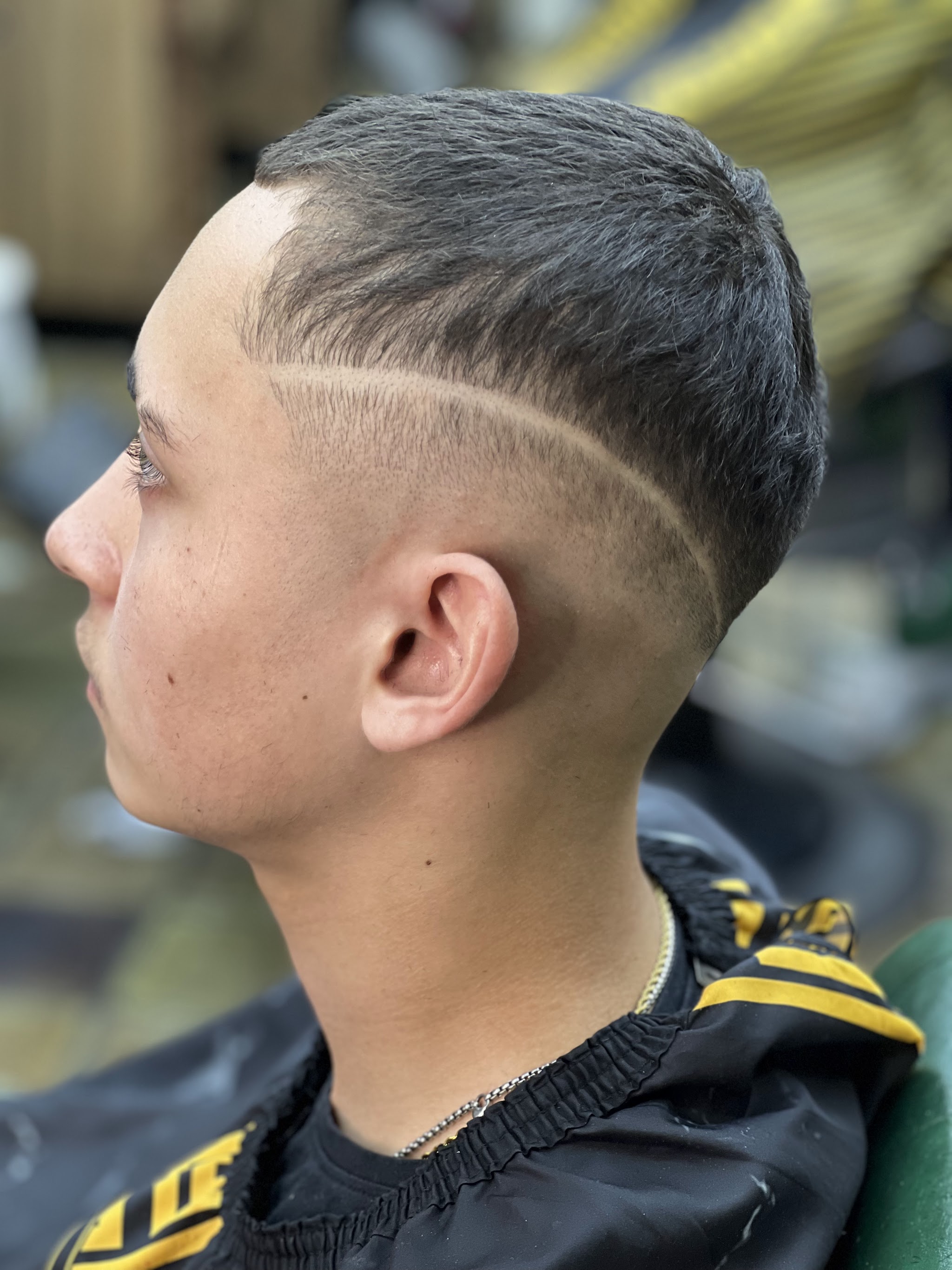 Zijaanzicht van een skin fade met een scherpe lijn in het haar